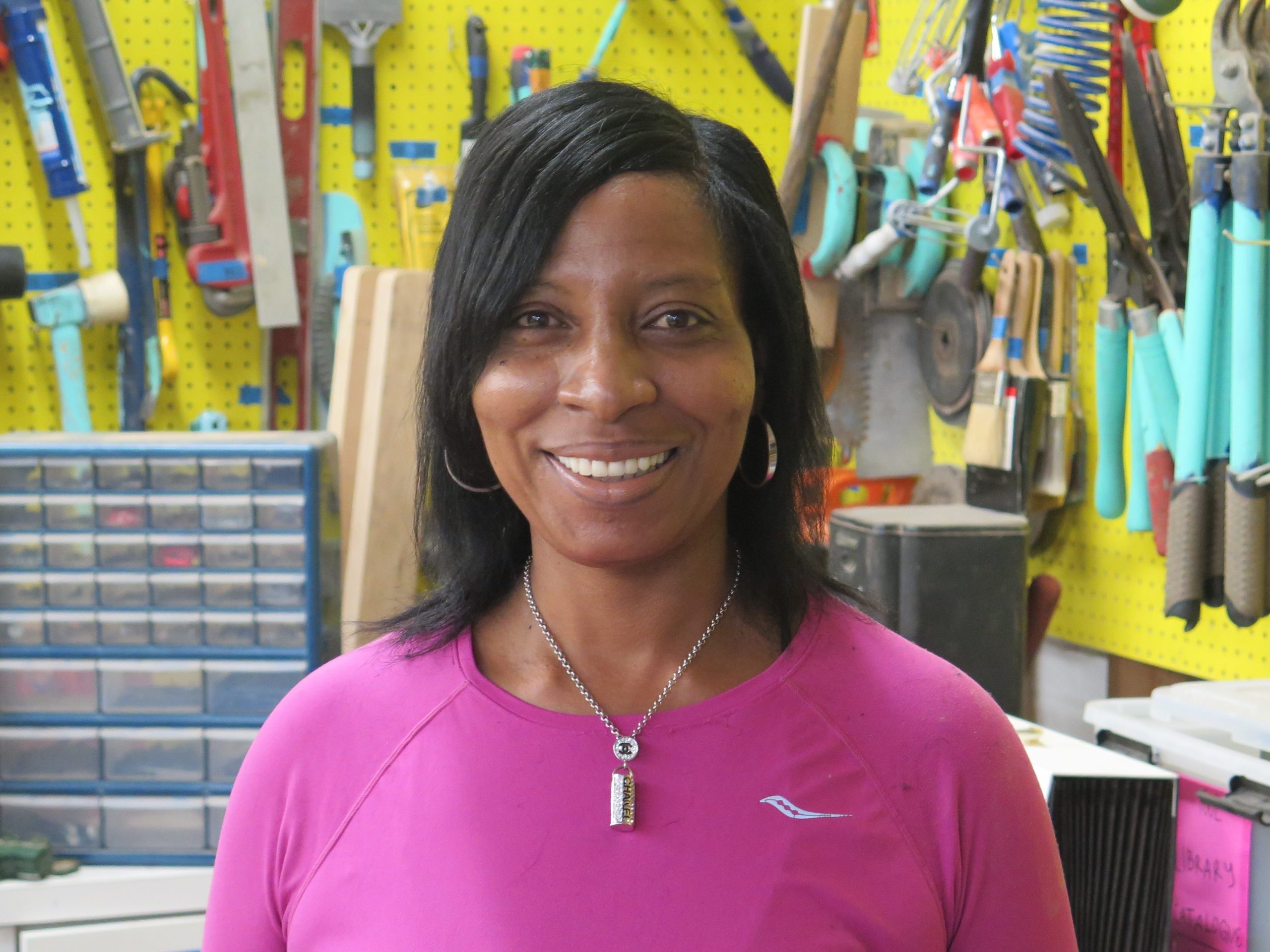 Loretta Davis is smiling in this photo. She has dark, shoulder-length hair and is wearing a bright pink shirt.
