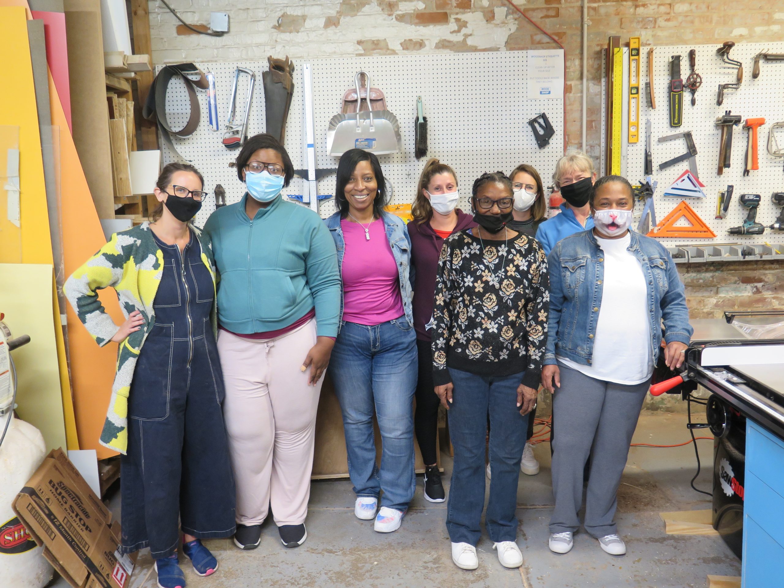 This photo shows eight women who are part of the Owning Your Own Voice woodworking class.