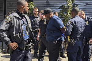 New York City Police, left, and law enforcement officials lead subway shooting suspect Frank R. James, 62, right, into a car and away from a police station, in New York, Wednesday, April 13, 2022. The man accused of shooting multiple people on a Brooklyn subway train was arrested Wednesday and charged with a federal terrorism offense. (AP Photo/Seth Wenig)