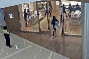 A suspect flees from Kenwood Towne Center's Louis Vuitton store after more than $400,000 in items were stolen