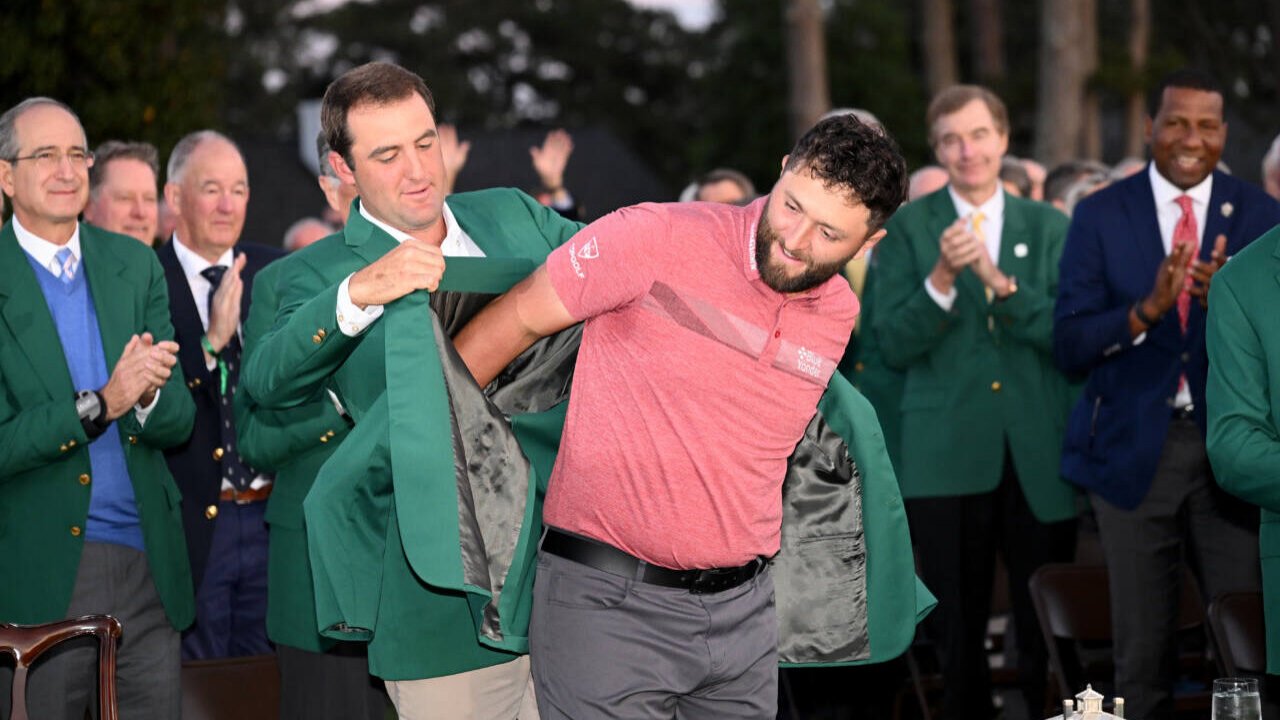 Tiger Woods receiving his Masters green jacket from champion Vijay Singh.