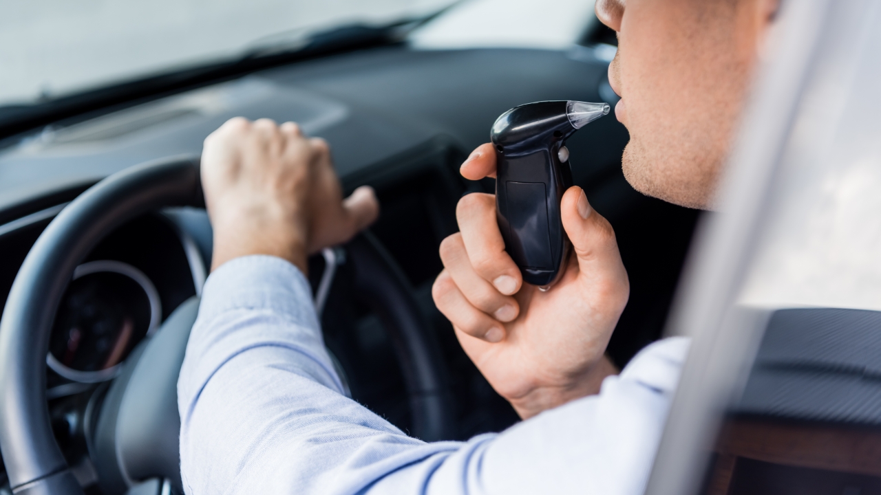 A driver takes a breathalyzer test.