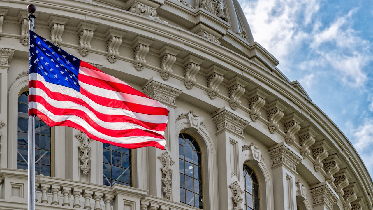 An American flag waves in front of the U.S. Capitol dome in D.C.