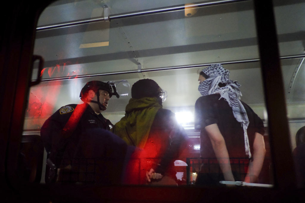 Members of the New York Police Department strategic response team load arrested protesters from Columbia University onto a bus