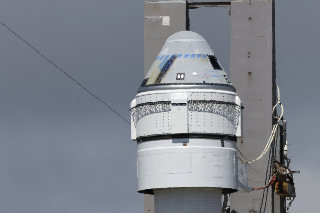 Boeing's Starliner capsule atop an Atlas V rocket is rolled out to the launch pad.