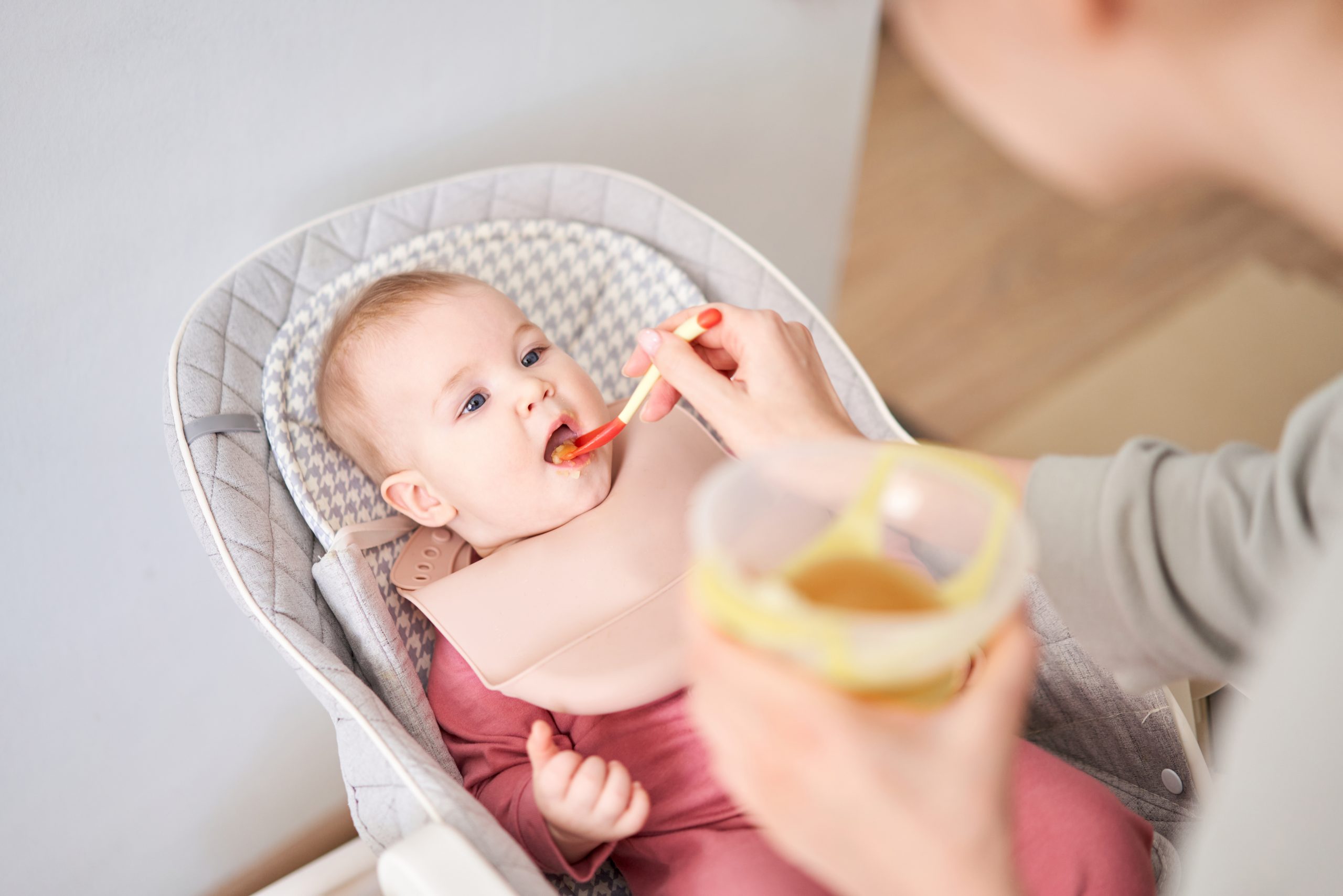Mother feeding her baby daughter