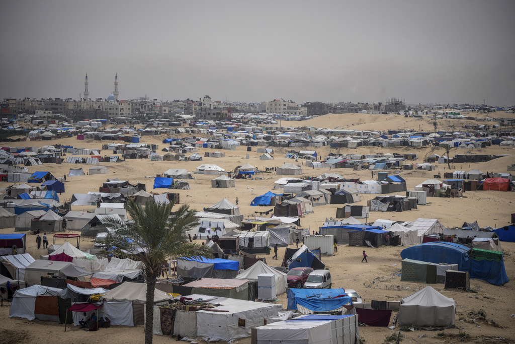 Palestinians displaced by the Israeli air and ground offensive on the Gaza Strip walk through a makeshift tent camp in Rafah, Gaza.