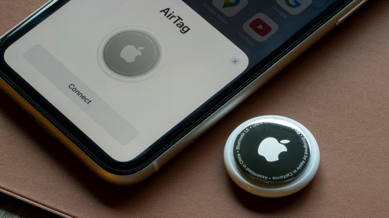 An AirTag is seen being connected to an iPhone.