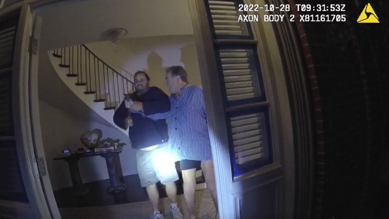 Husband of former U.S. House Speaker Nancy Pelosi, Paul Pelosi, right, fights for control of a hammer with his assailant.