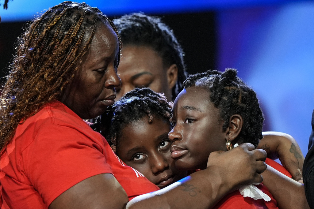 Meka Fortson, left, the mother of slain airman Roger Fortson, holds family members during a news conference describing details of the airman's death.