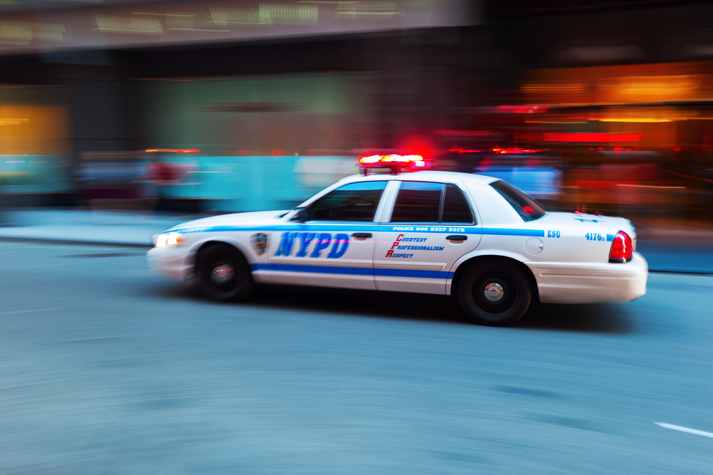 A New York Police Department cruiser zipping through with its lights flashing.