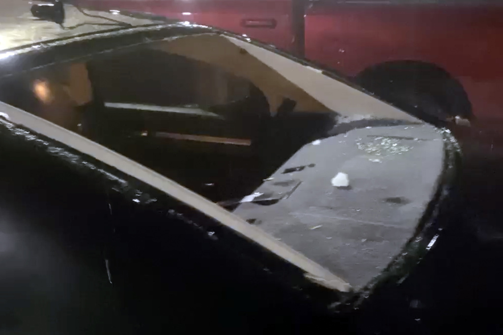 This image taken from video provided by JJ Unger, shows hail damage to a window of vehicle.