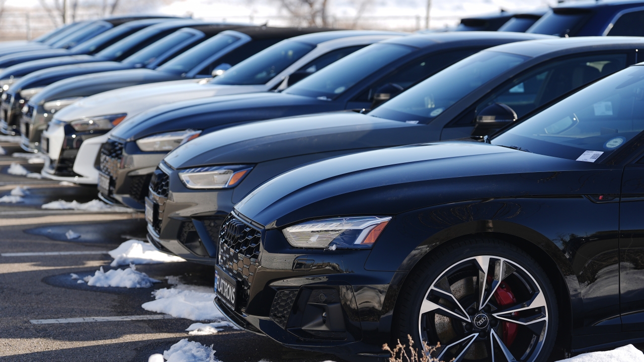 Unsold 2023 sedans sit in a long row outside an Audi dealership Sunday, Feb. 11, 2024.