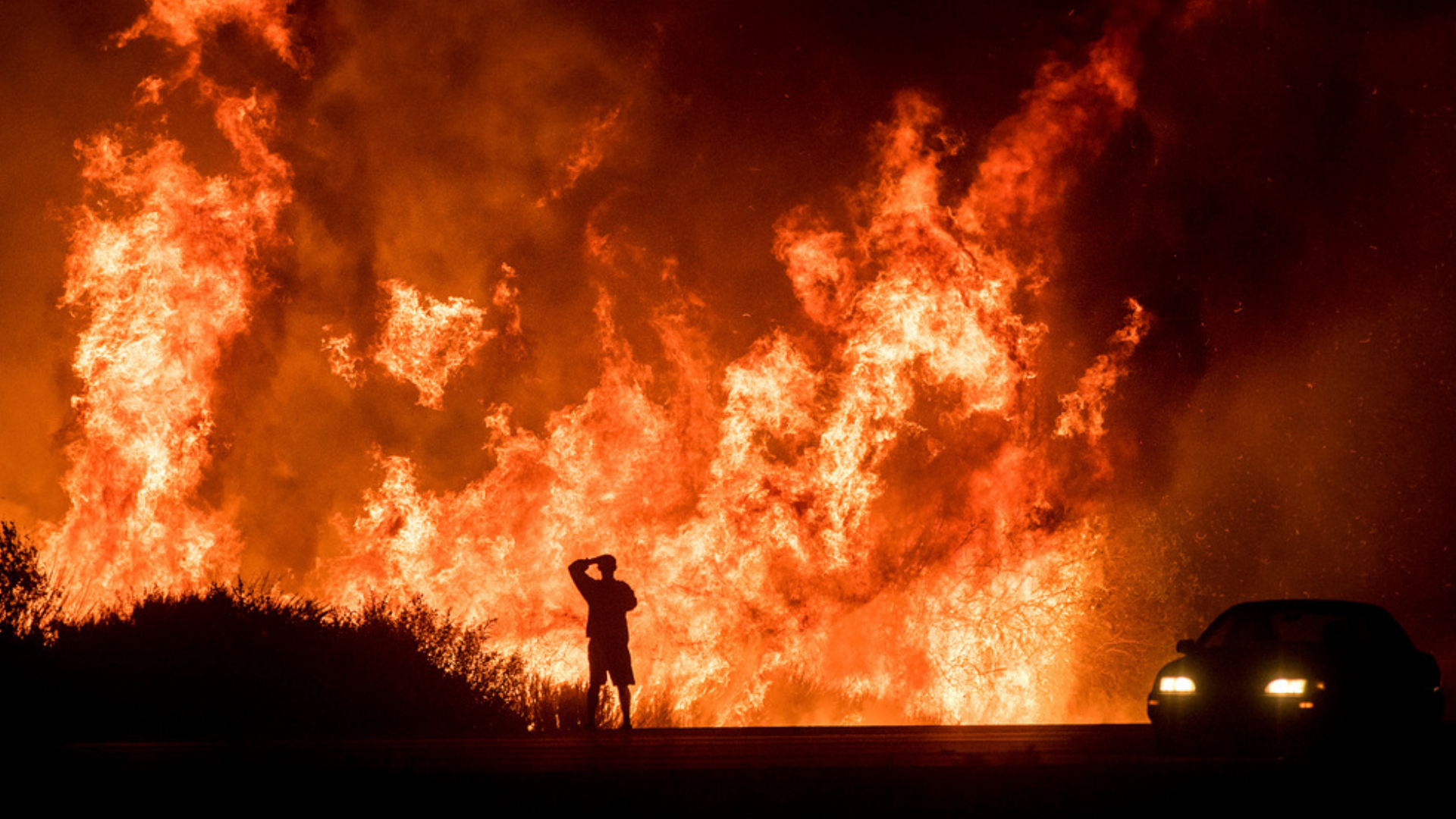 A motorists on Highway 101 watches flames from the Thomas Fire.