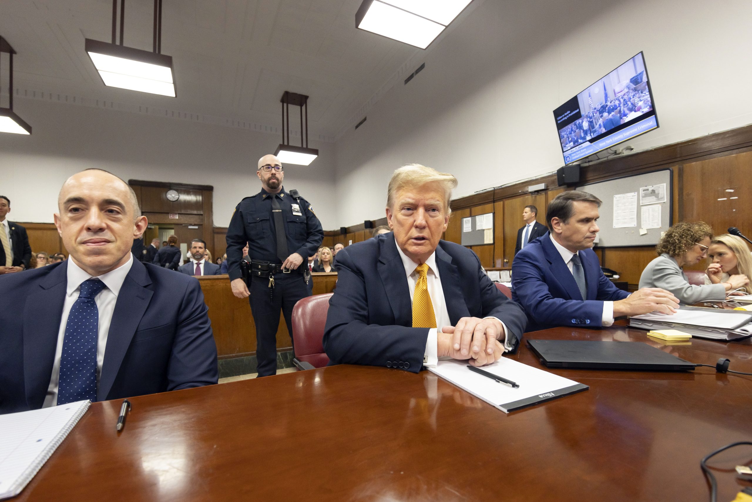 Former President Donald Trump, center, sits in Manhattan Criminal Court with his attorneys Emil Bove, left, and Todd Blanche.