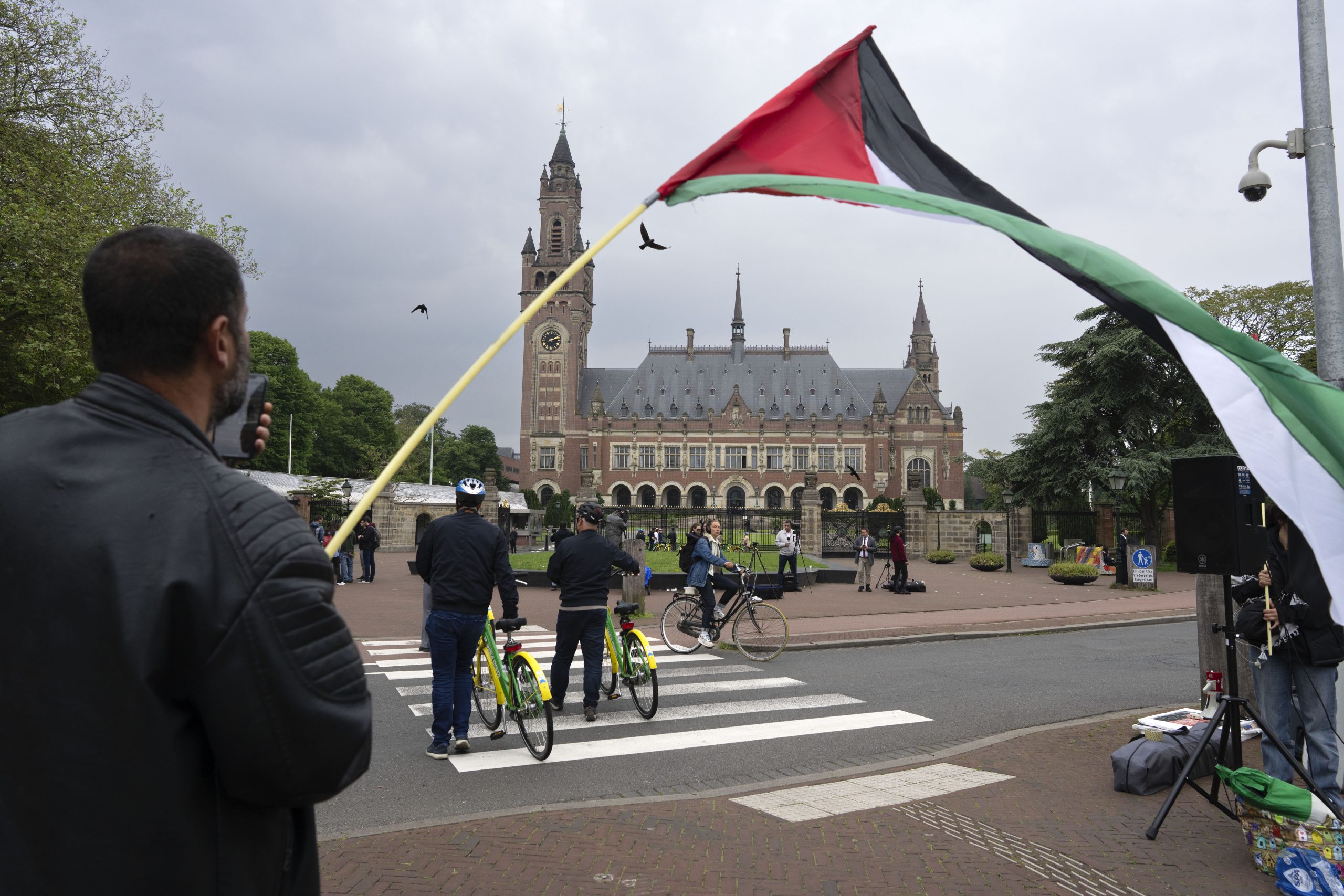 A lone demonstrator waves the Palestinian flag outside the Peace Palace housing the International Court of Justice.