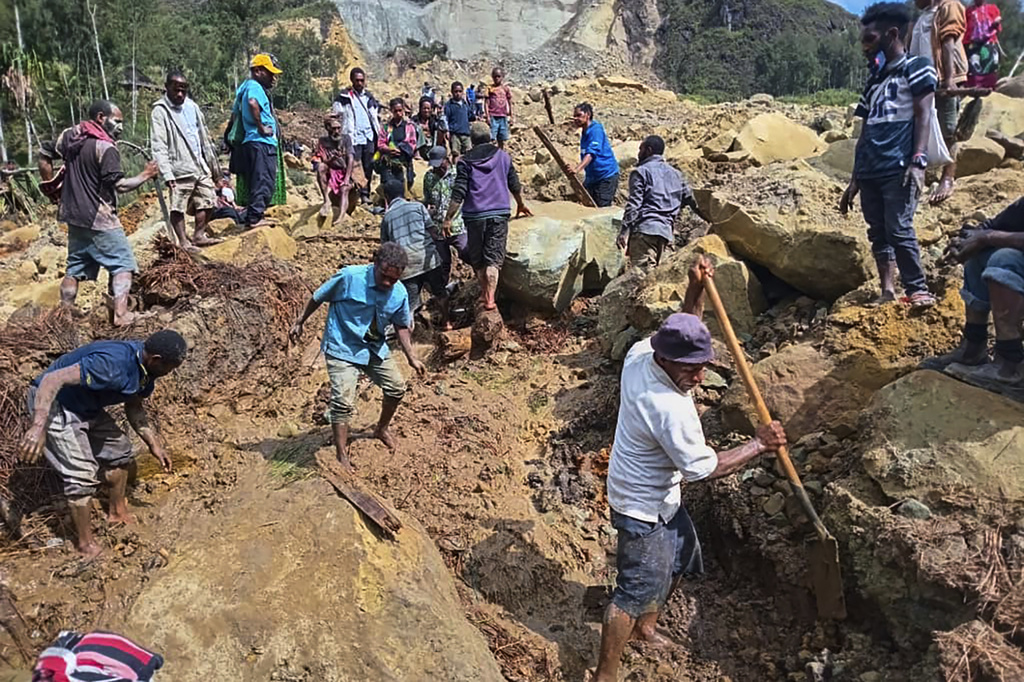 Villagers search through a landslide in Yambali, in the Highlands of Papua New Guinea