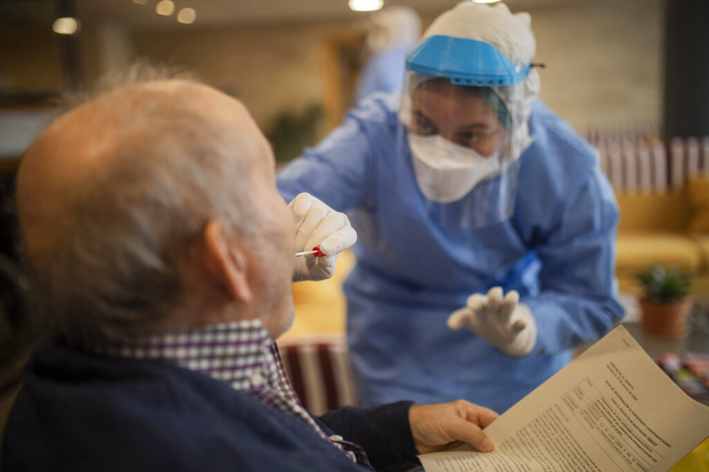 Medical professional administers a COVID-19 test to a patient via an oral swab