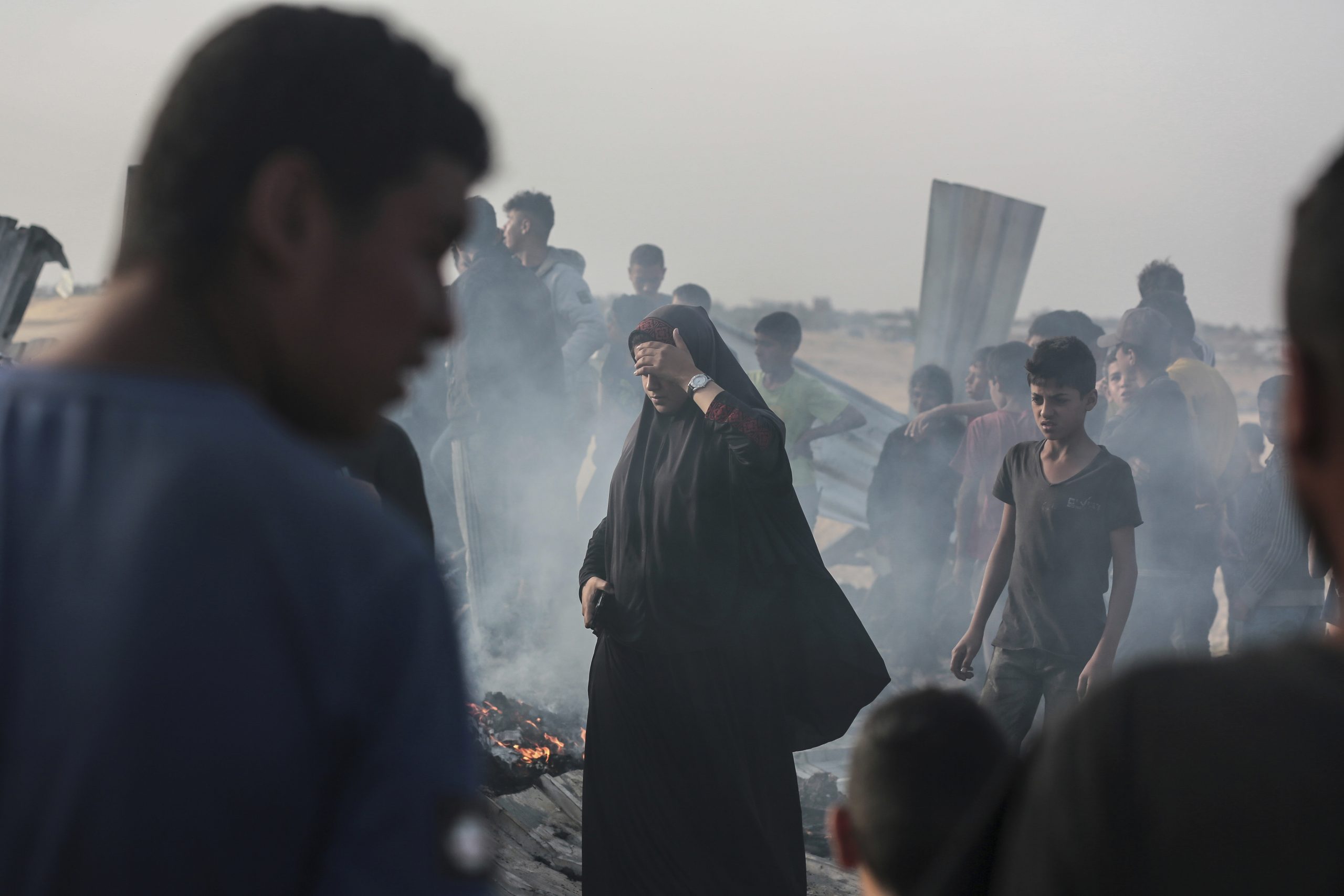 Palestinians look at the destruction after an Israeli strike where displaced people were staying in Rafah, Gaza Strip.