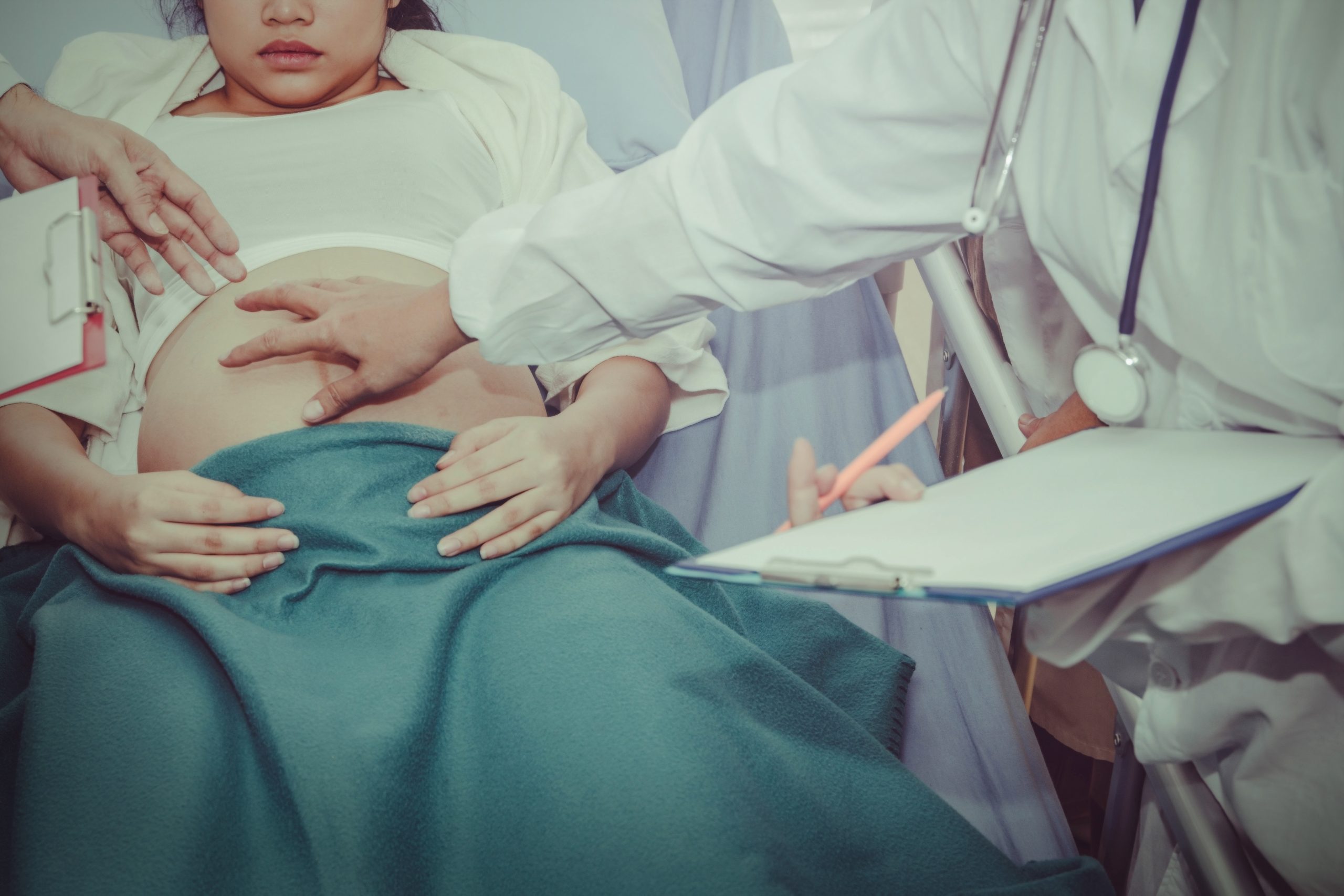 A pregnant woman gets examined from a hospital bed