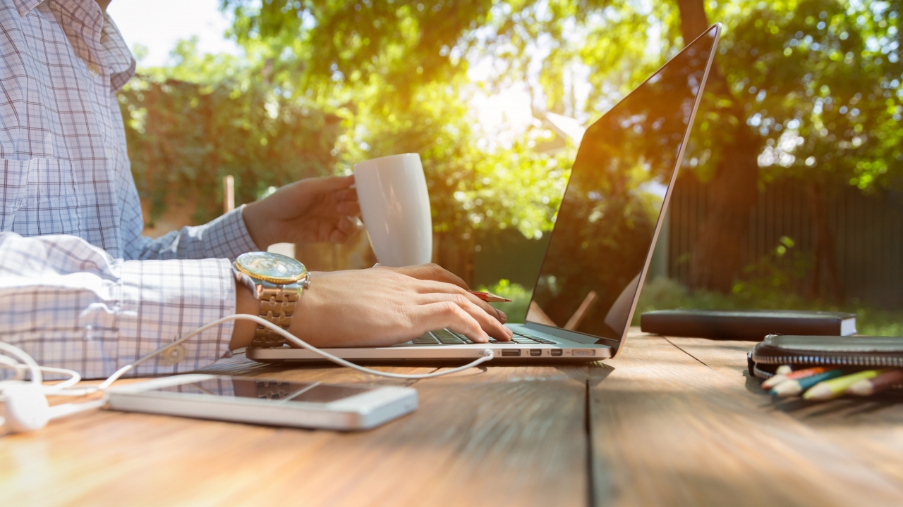 Person working remotely on a laptop outdoors