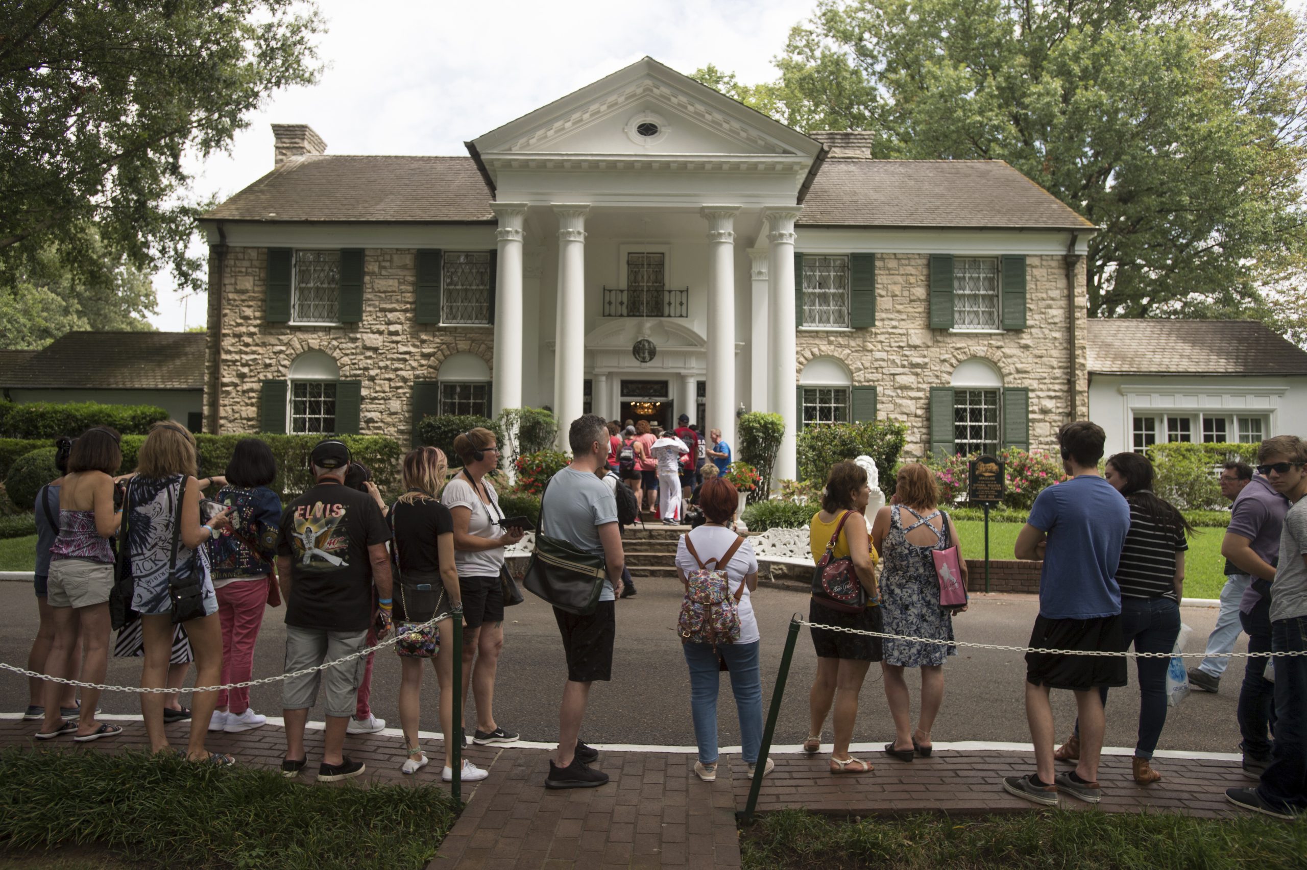 Fans of Elvis Presley wait in line outside Graceland in Memphis, Tenn.