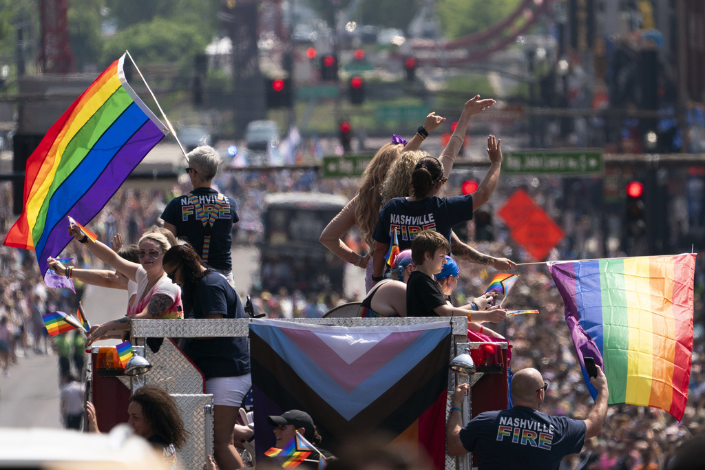 Nashville Pride Parade participants wave to spectators.