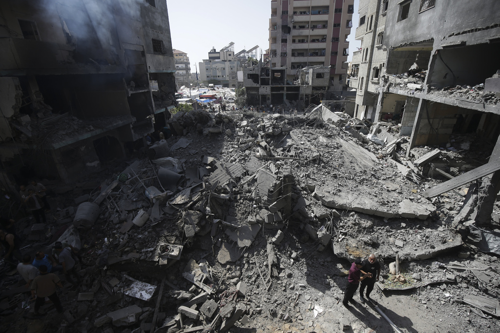 Palestinians look at the aftermath of the Israeli bombing in Nuseirat refugee camp