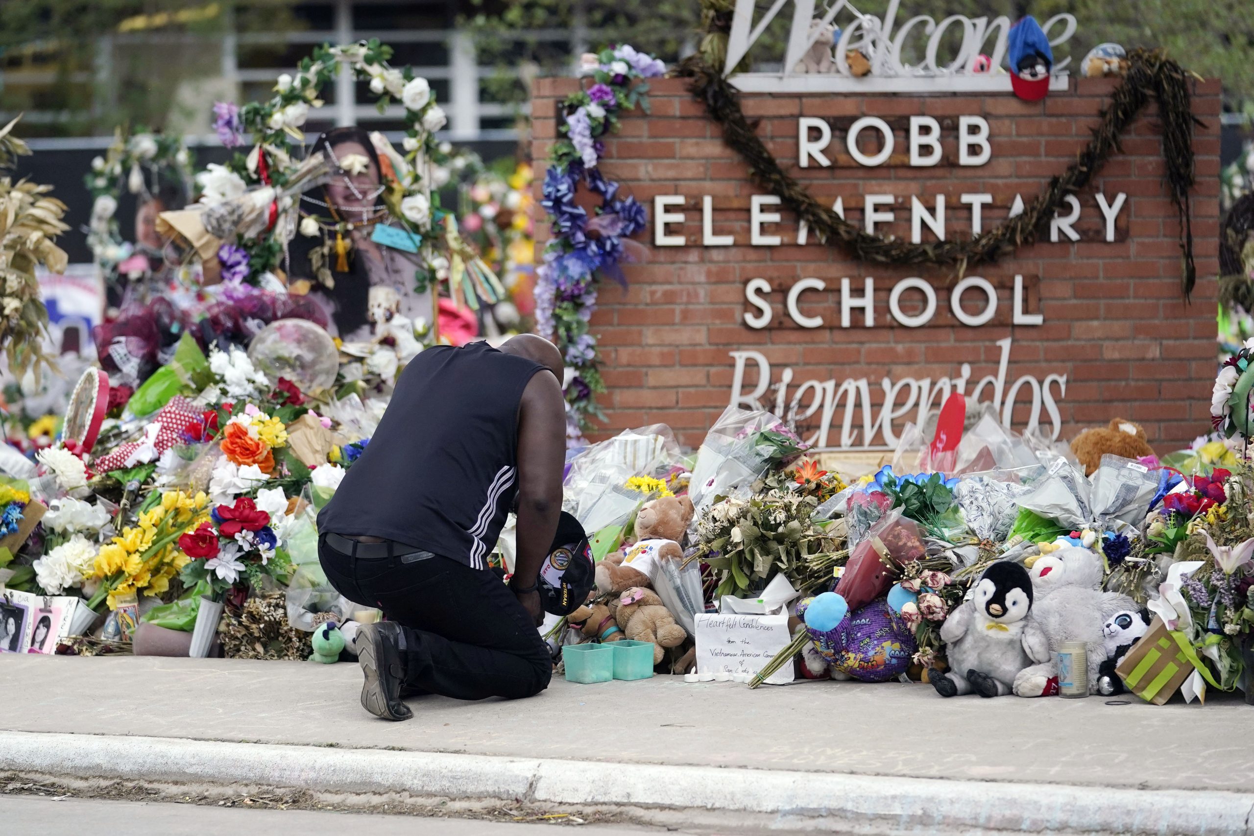 A person pays respects at a memorial at Robb Elementary School.