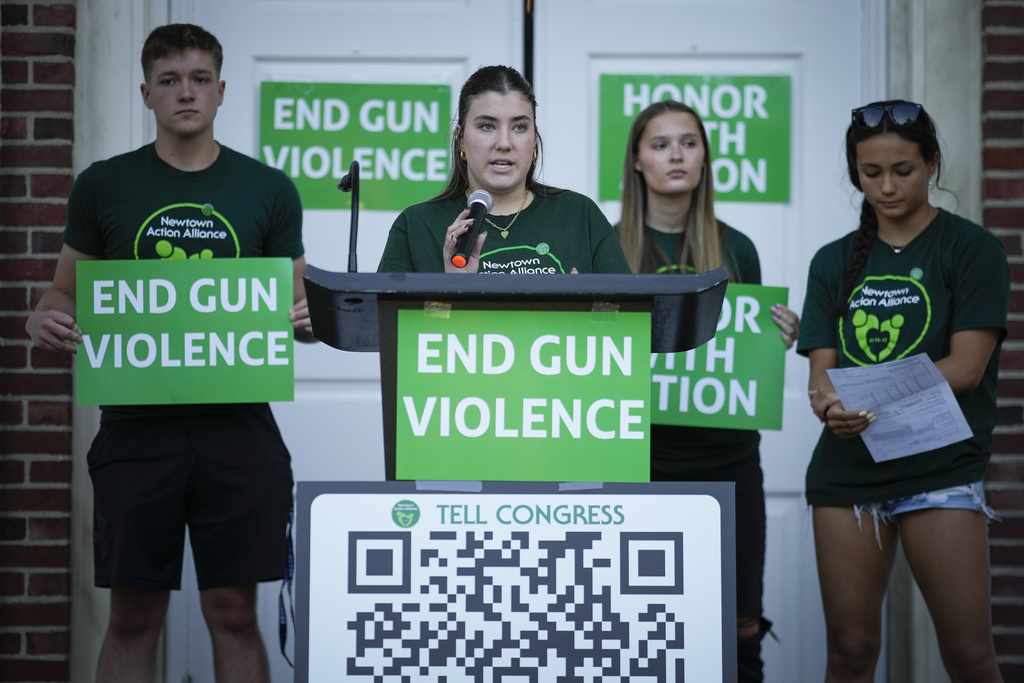 Emma Ehrens, center, a survivor of the 2012 Sandy Hook Elementary School shooting, speaks at a rally against gun violence.