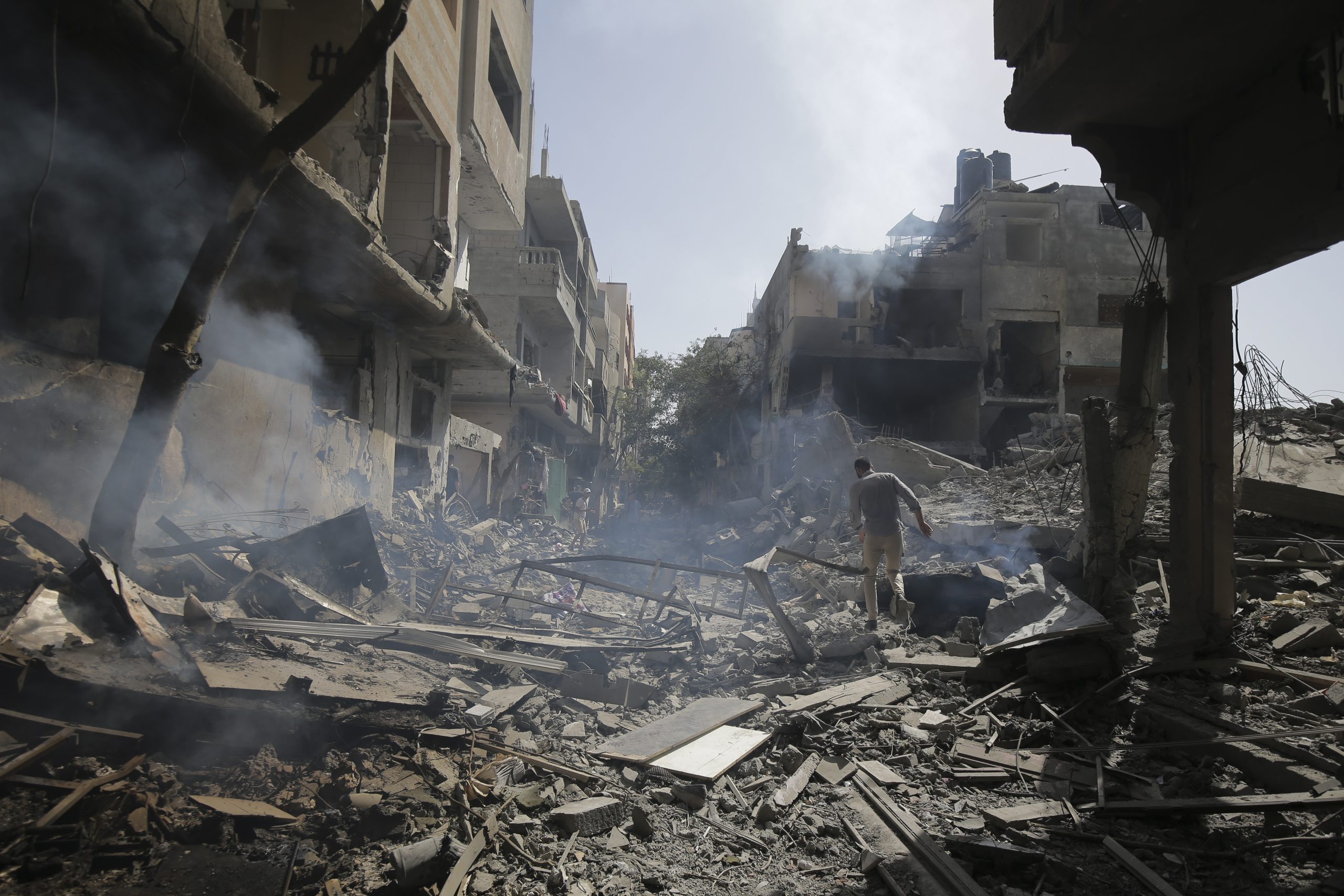Palestinians look at the aftermath of the Israeli bombing in Nuseirat refugee camp, Gaza Strip.
