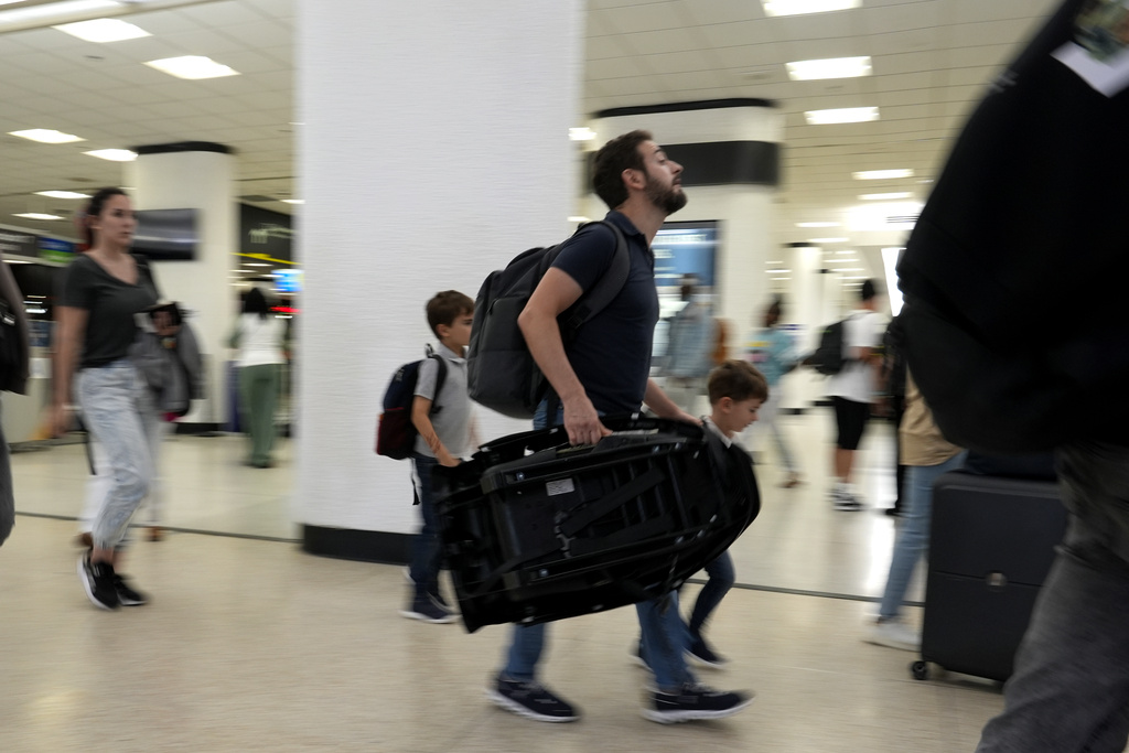 Travelers walk through the concourse at Miami International Airport.