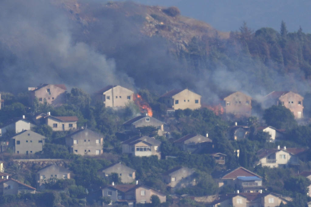 Fires and smoke rise at houses in the northern Israeli border town of Metula