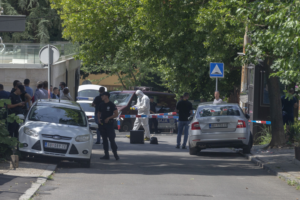 Police officers work at a crime scene close to the Israeli embassy in Belgrade, Serbia