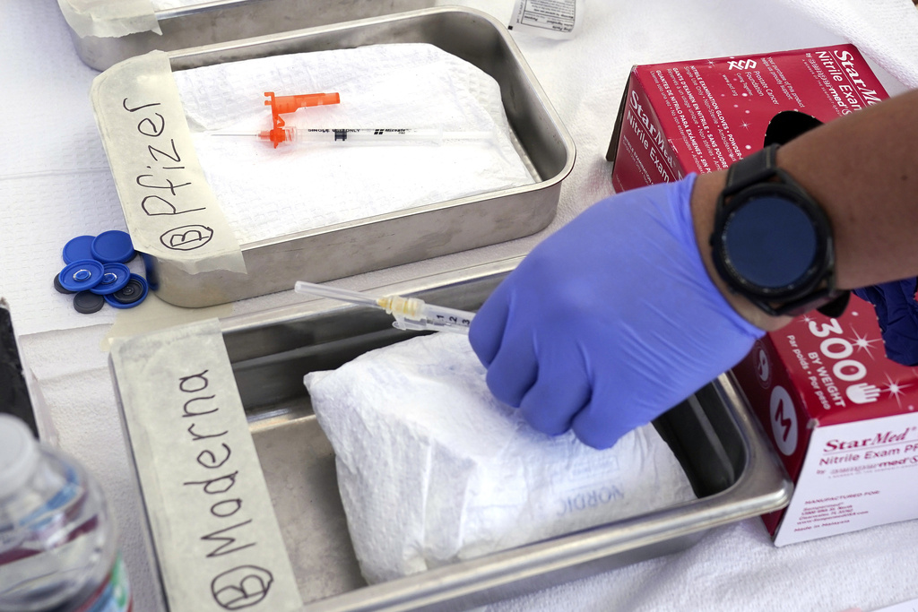 Syringes with vaccines are prepared at a health clinic. 