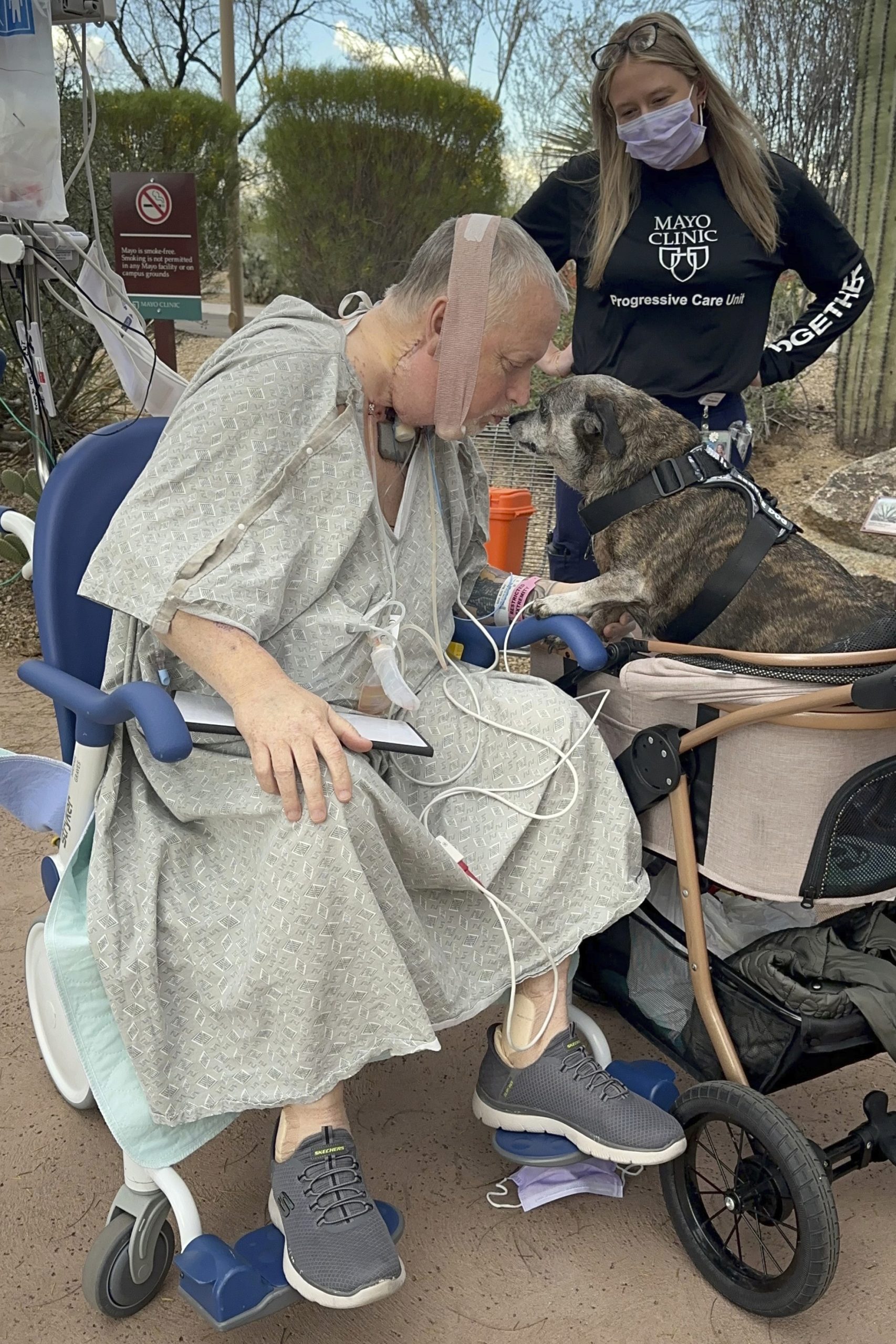 In this photo provided by the Mayo Clinic, Marty Kedian greets his dog, Baxter, on his first trip outside the Mayo Clinic Hospital after his surgery.
