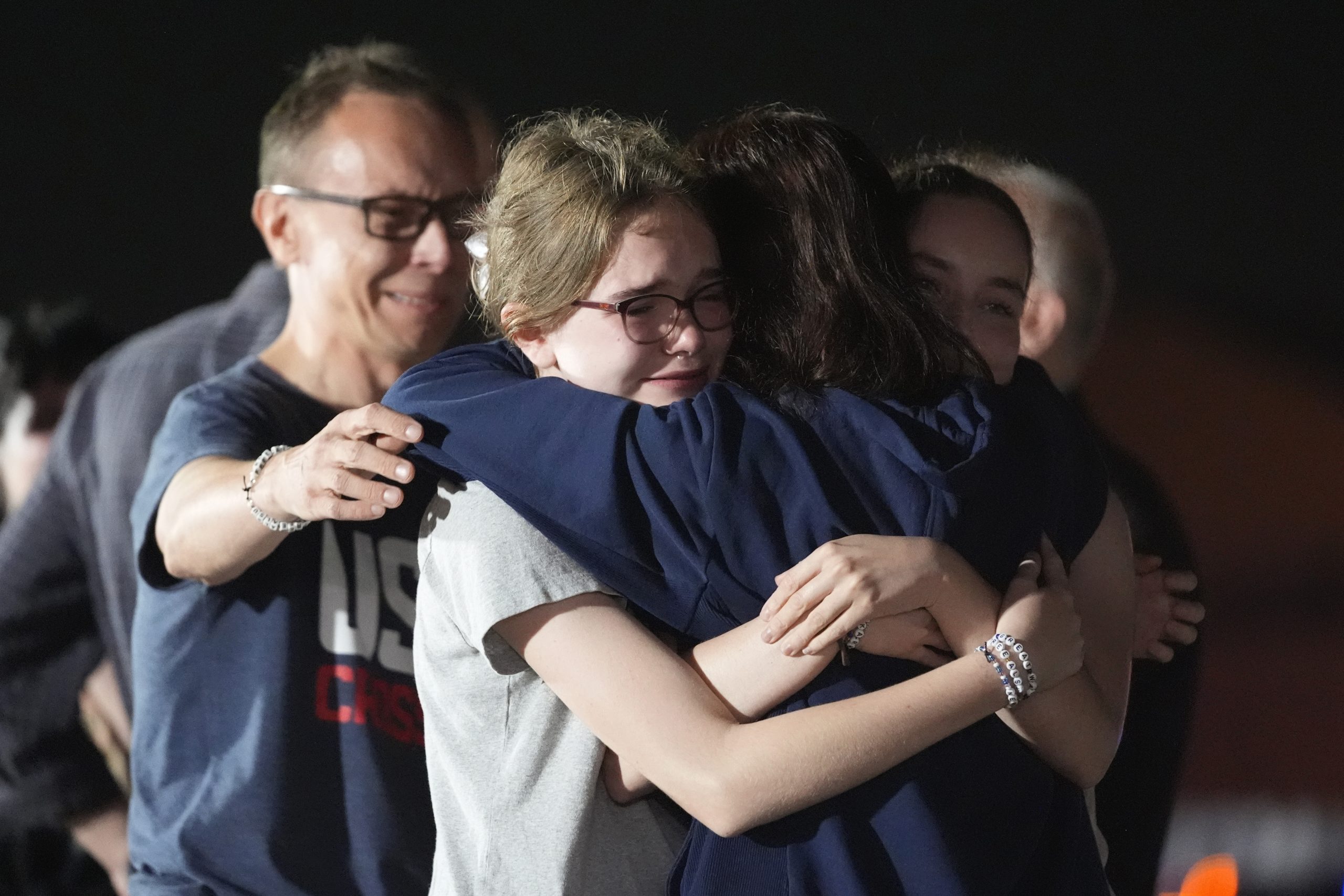 Alsu Kurmasheva, second right, hugs her husband Pavel Butorin, from left, and daughters Miriam Butorin and Bibi Butorin at Andrews Air Force Base in Maryland.