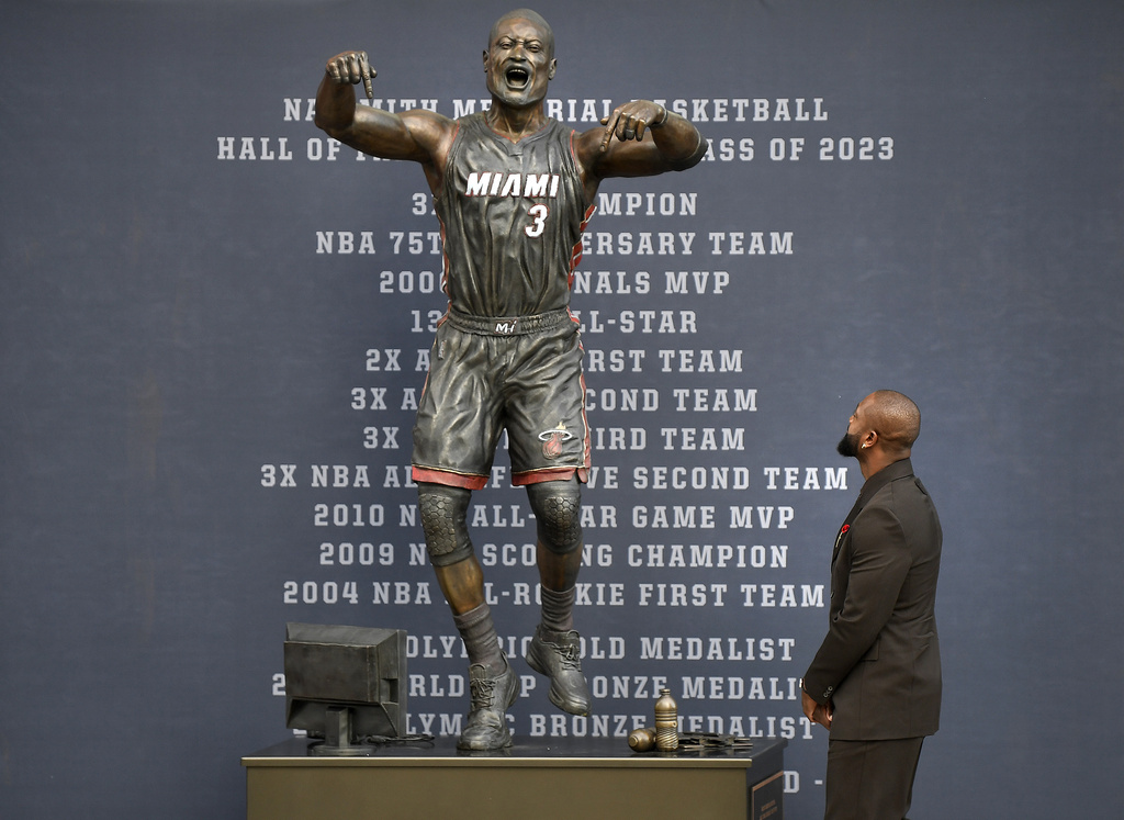 Former Miami Heat NBA basketball player Dwyane Wade looks at a bronze statue