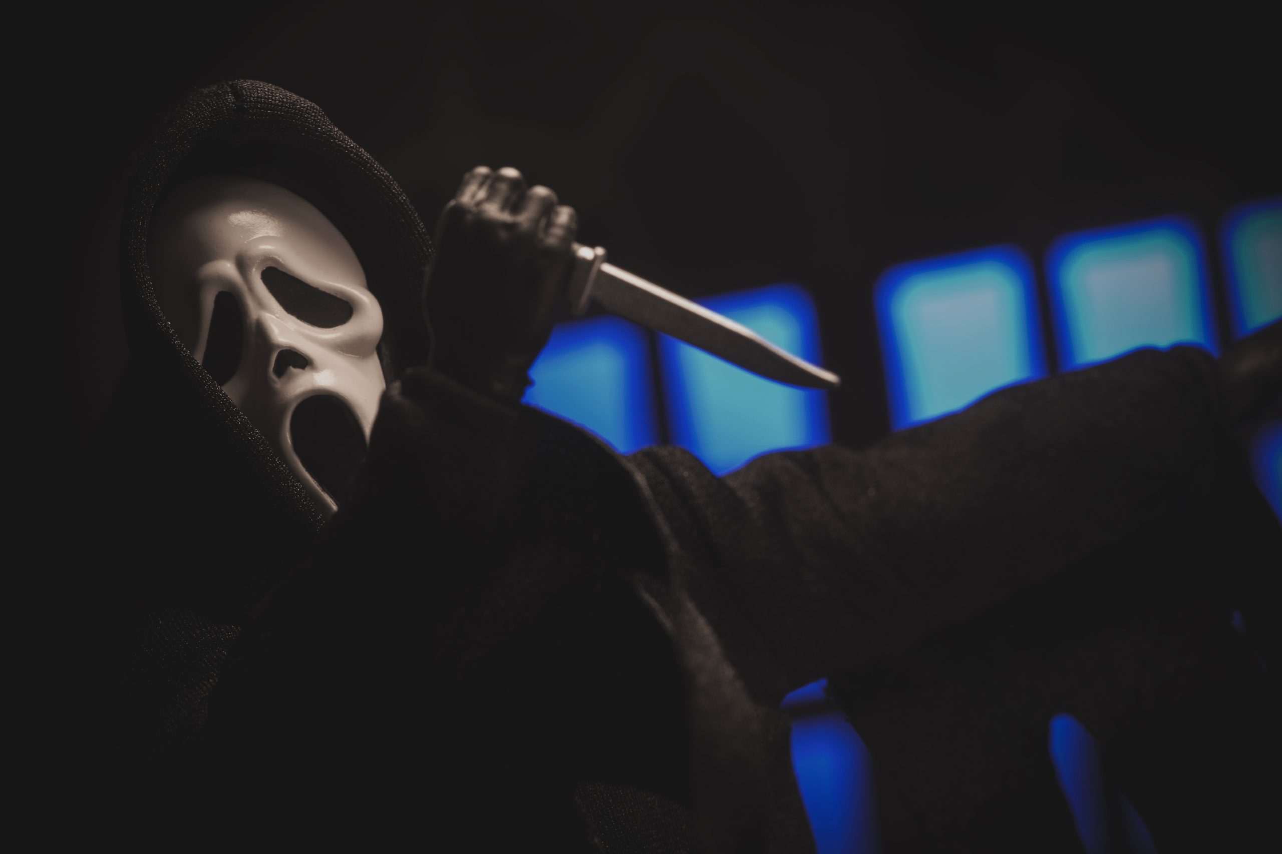Person in a "Scream" mask holds a knife