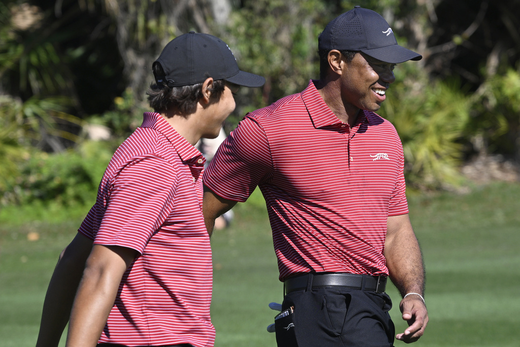 Tiger Woods, right, congratulates his son Charlie Woods after his hole-in-one on the fourth hole during the final round of the PNC Championship golf tournament.