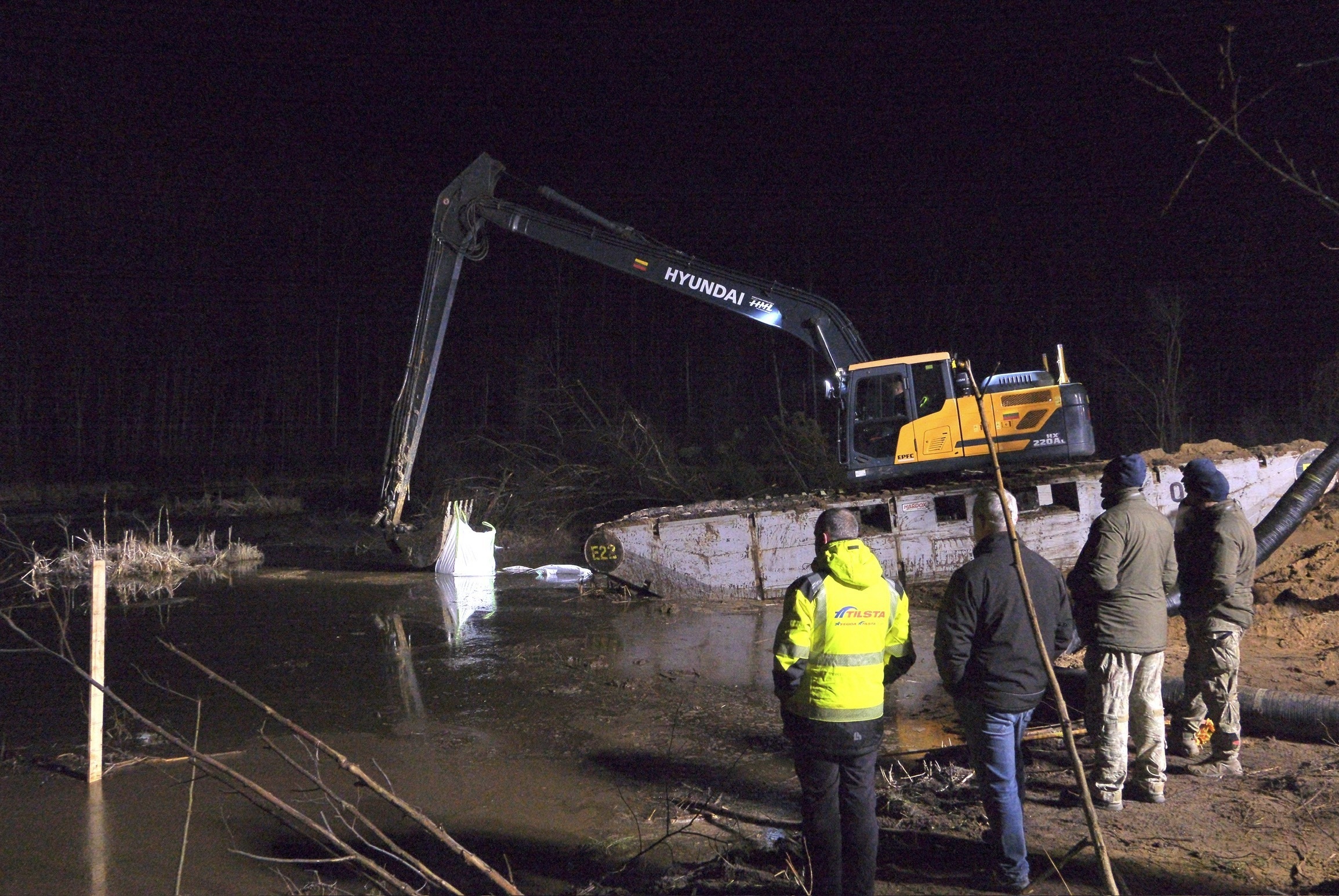 In this image provided by the U.S. Army, Lithuanian Army and emergency services personnel build a makeshift dam from HESCO barrier bags during recovery efforts for four U.S. soldiers in a U.S. Army M88 Hercules submerged under several meters of water in a swamp near a training area near Pabadre, Lithuania.