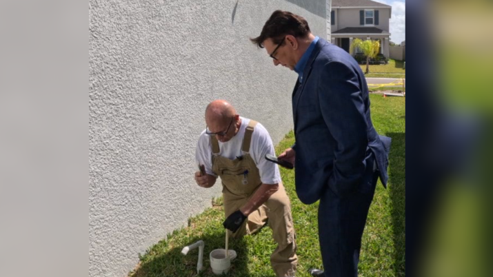 Thomas Flynn and Adam Walser search for latex glove in clean out between Wood's home and street