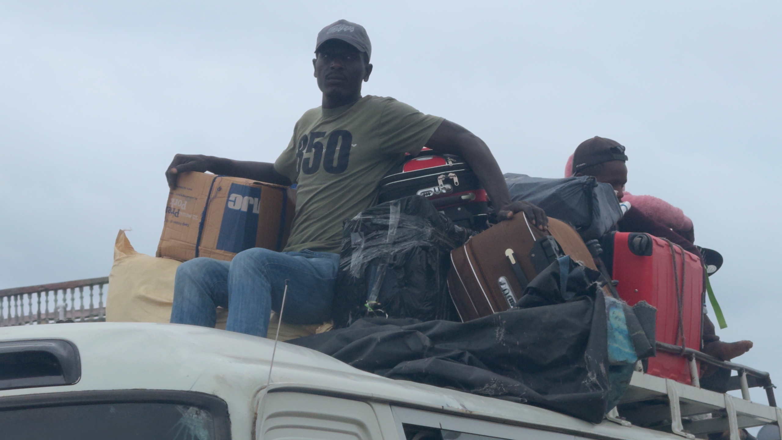 People sit on top of a bus in Haiti.