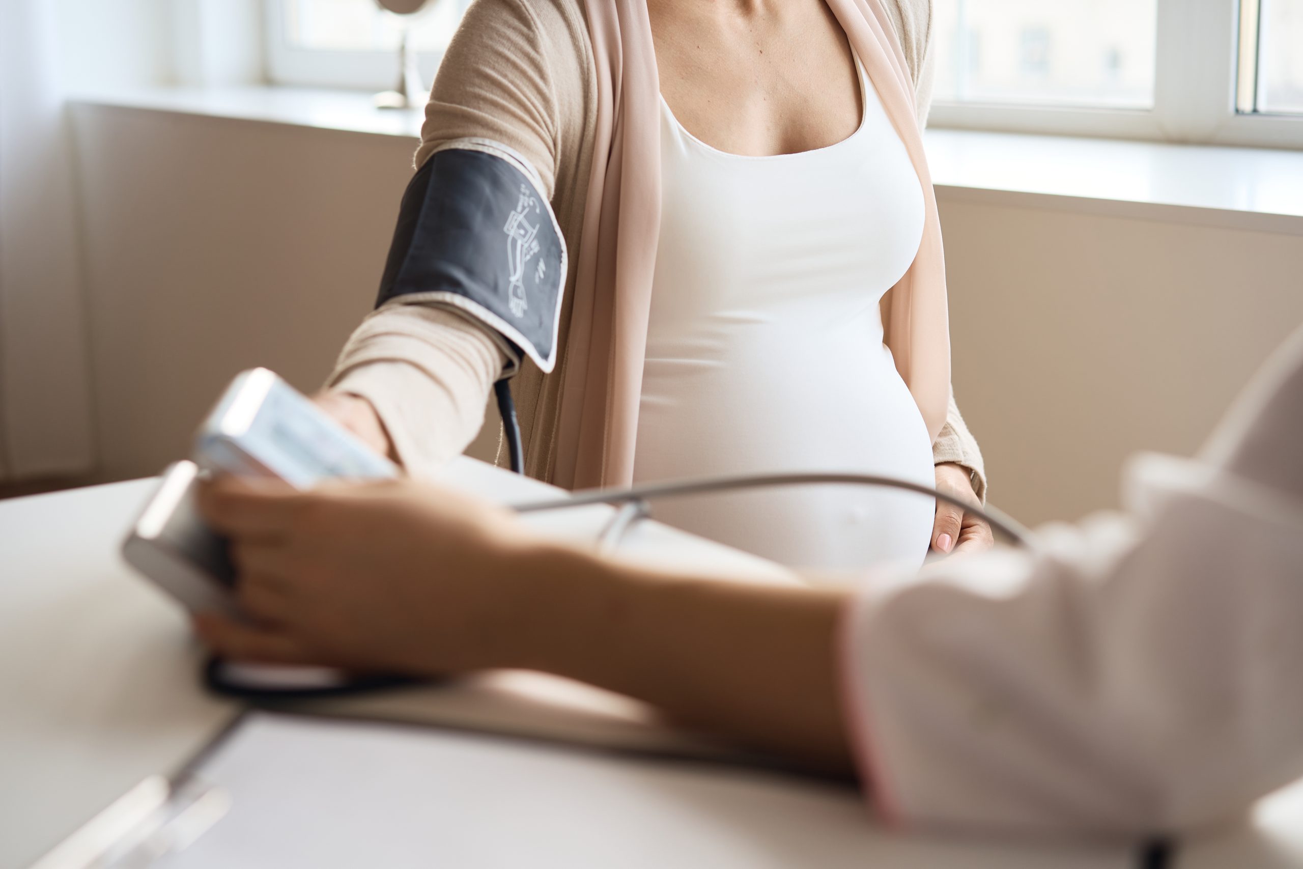 Doctor measuring blood pressure on pregnant patient
