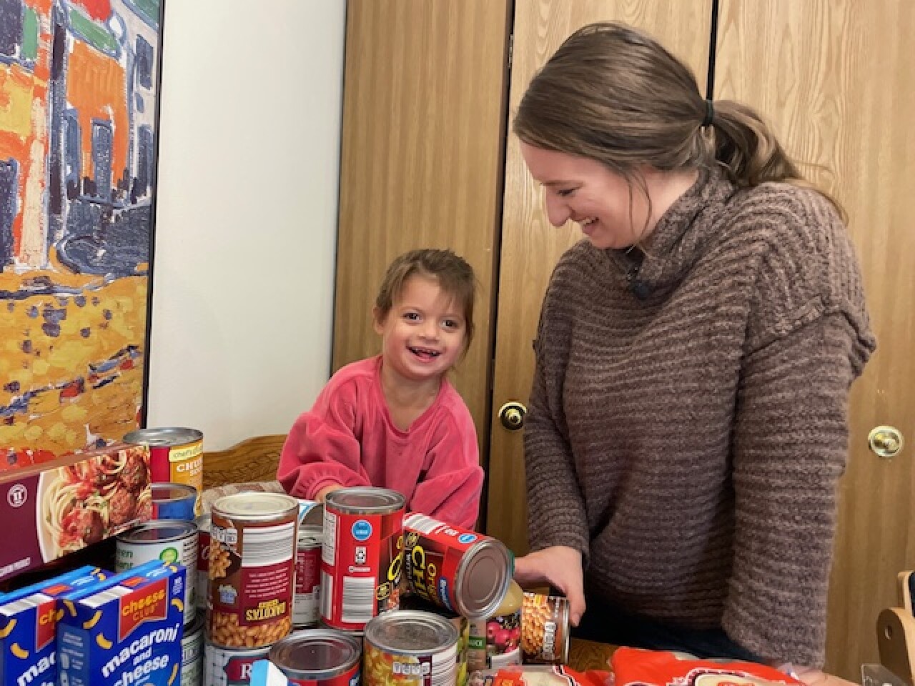 Rachel Hartberg and her daughter stand with donated items.