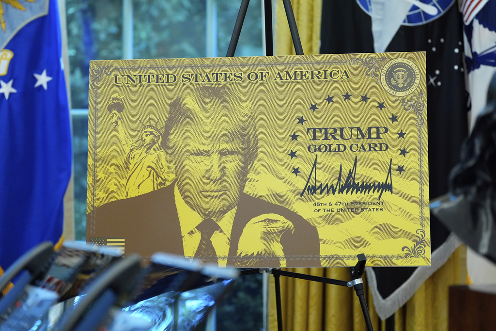 A poster showing the Trump Gold Card is pictured as President Donald Trump speaks in the Oval Office of the White House, Friday, Sept. 19, 2025, in Washington.