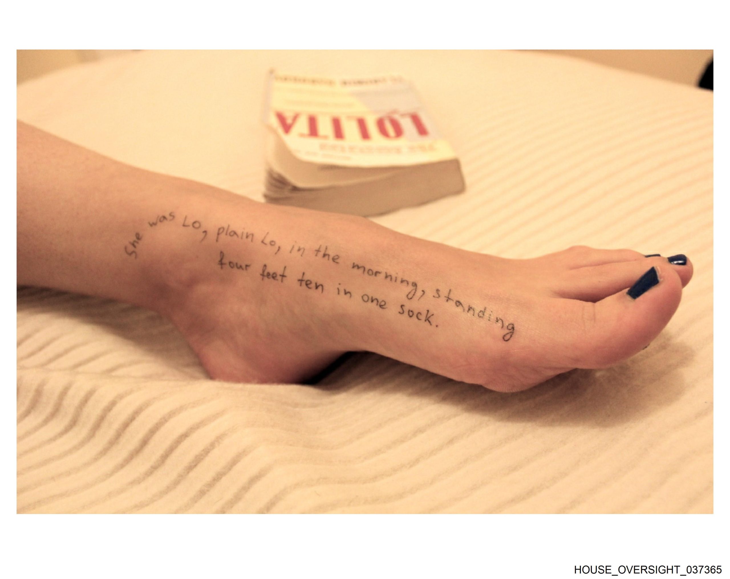 A picture of a woman with the book Lolita next to her.
